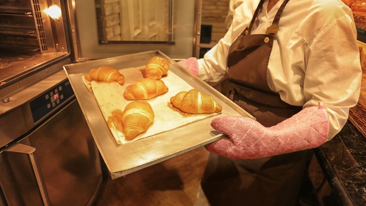 Padeiro tirando pães do forno.