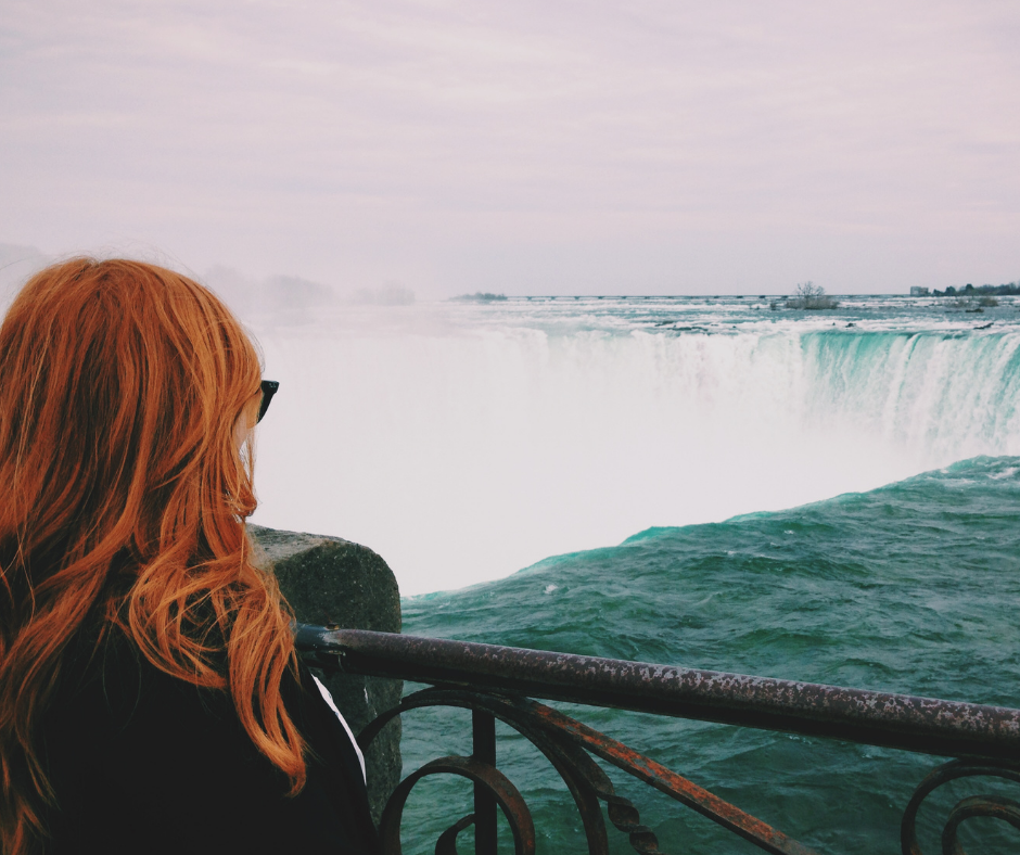 mulher observando uma cachoeira