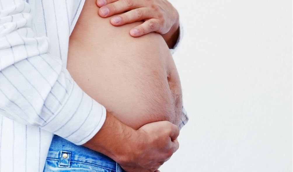 Homem segurando barriga como se estivesse grávido