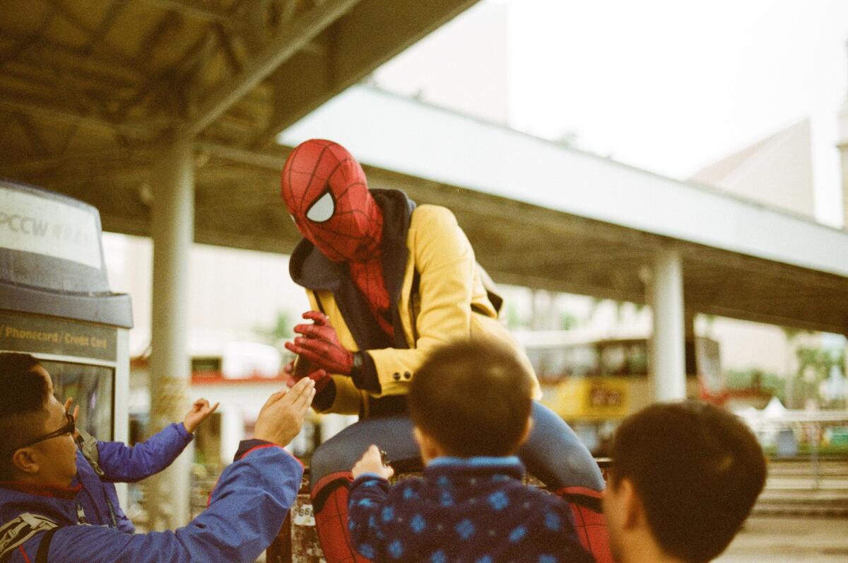 Homem fantasiado cercado por outras pessoas.