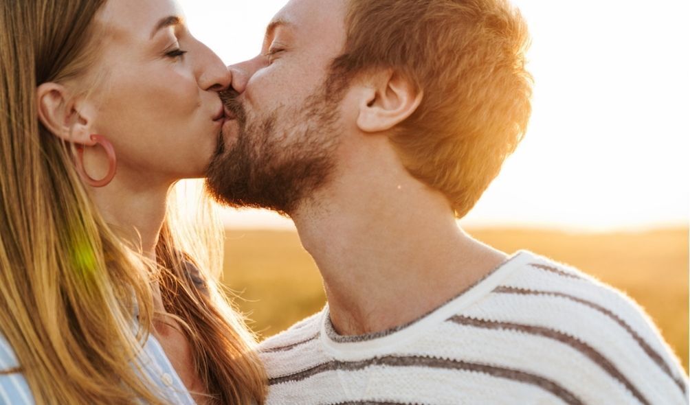 Casal se beijando no pôr do sol