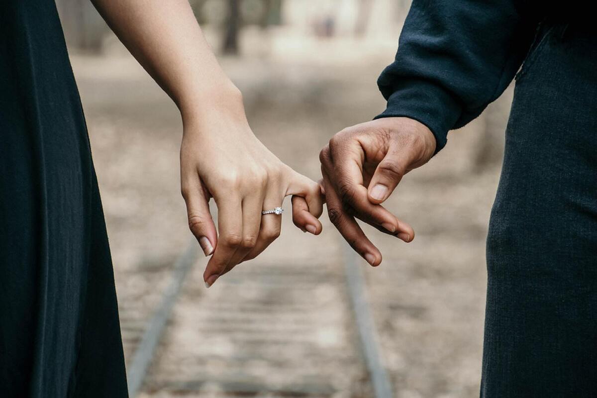 Casal apaixonado entrelaçando os dedos