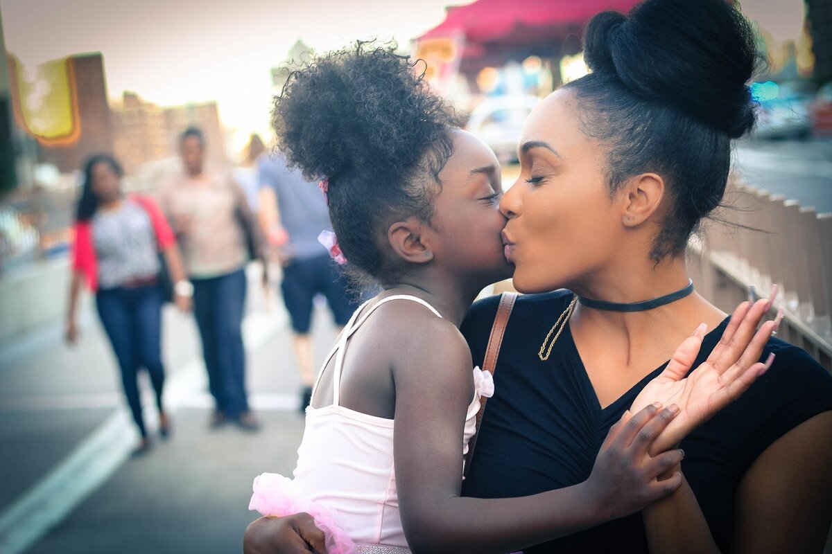 Mãe beijando sua filha.