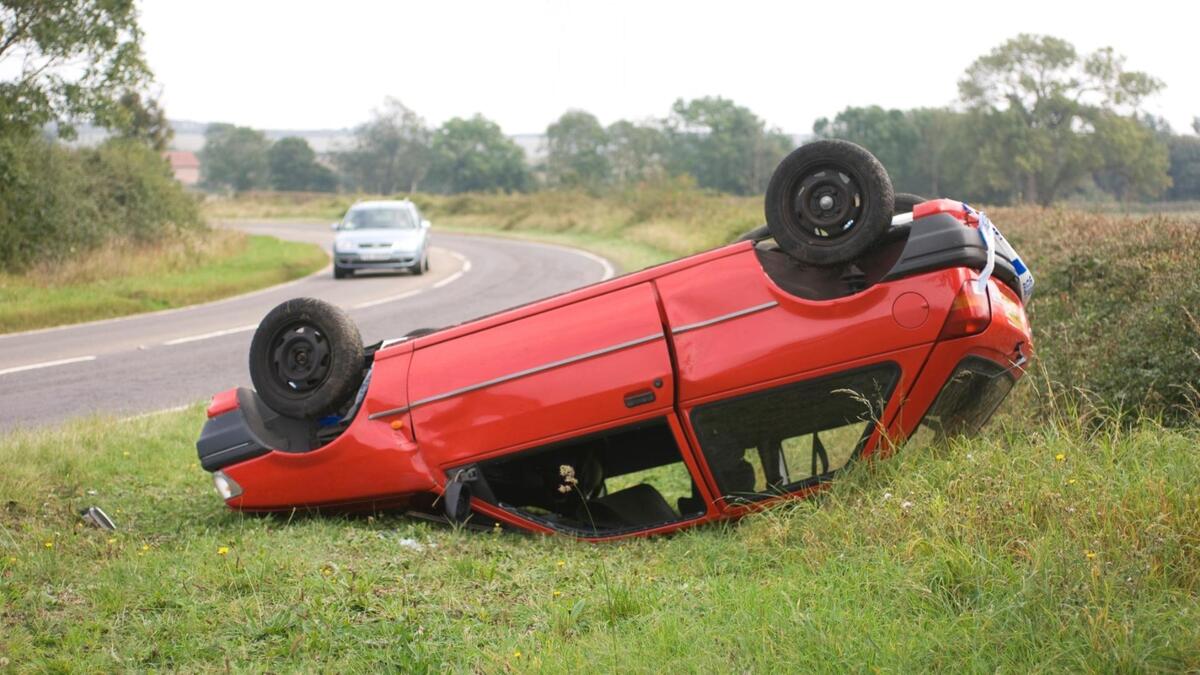 Carro vermelho capotado.