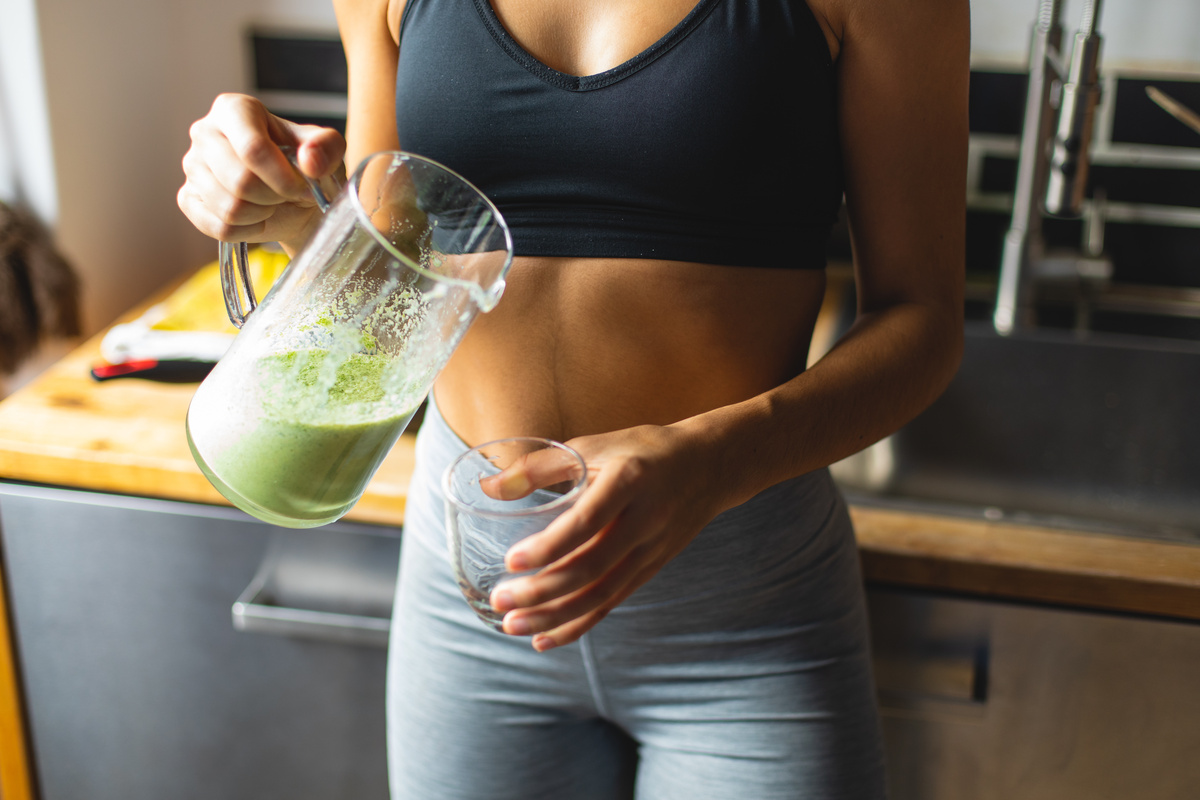 Mulher tomando suco verde