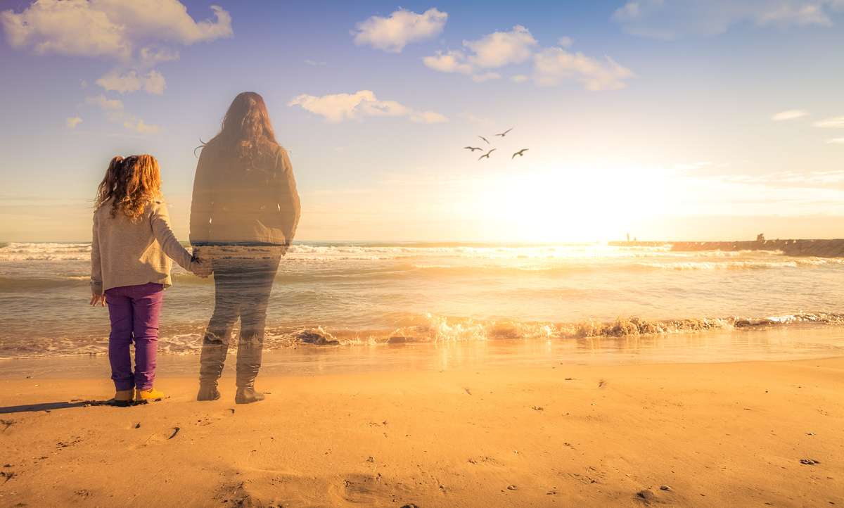 Menina na praia acompanhada do fantasma da mãe