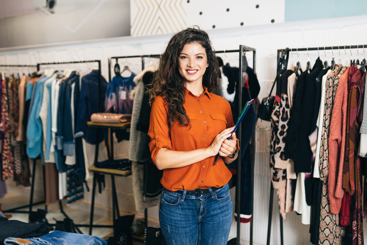 Vendedora sorridente em loja de roupas