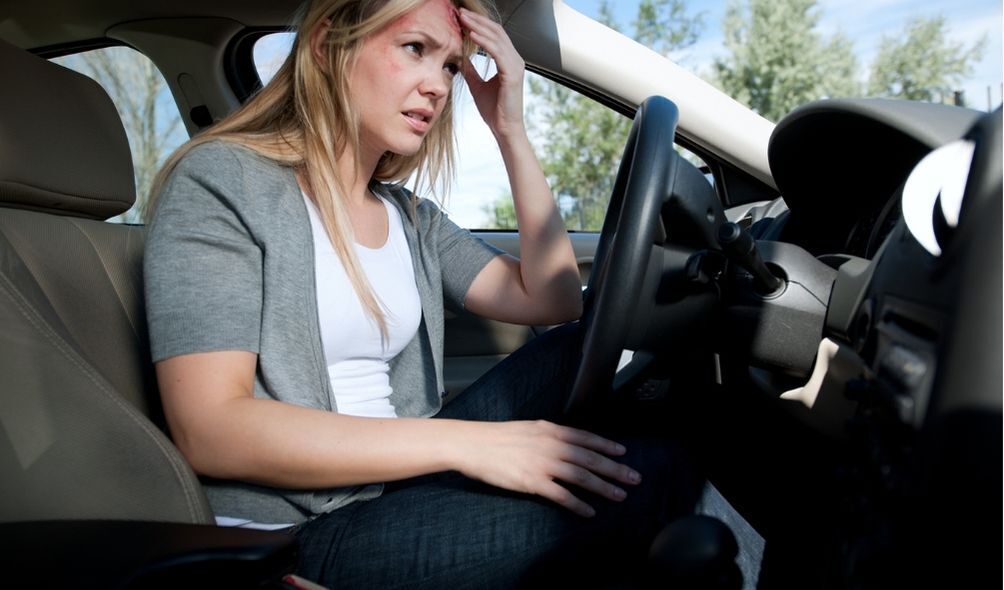 Mulher com a cabeça machucada no carro