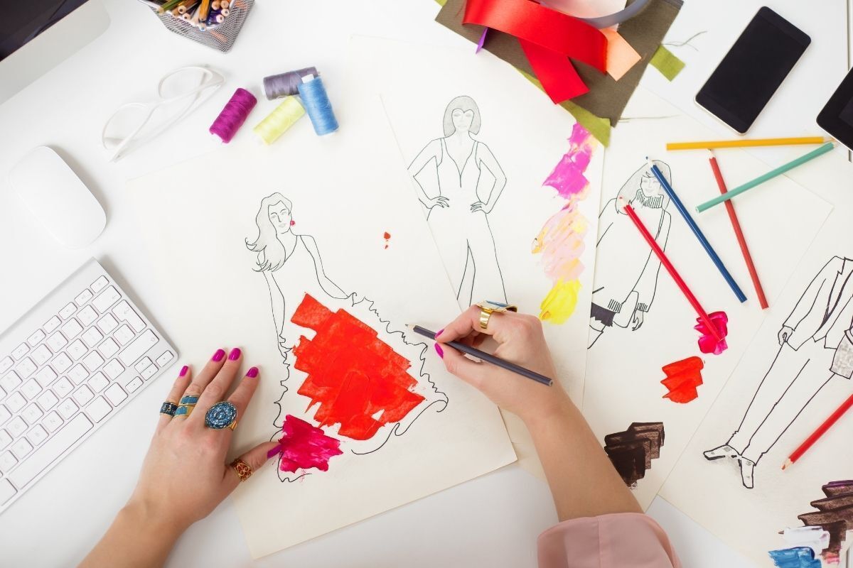 estilista desenhando um vestido para o desfile de moda