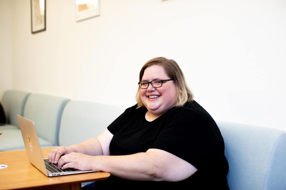 Mulher sorrindo, usando o notebook.