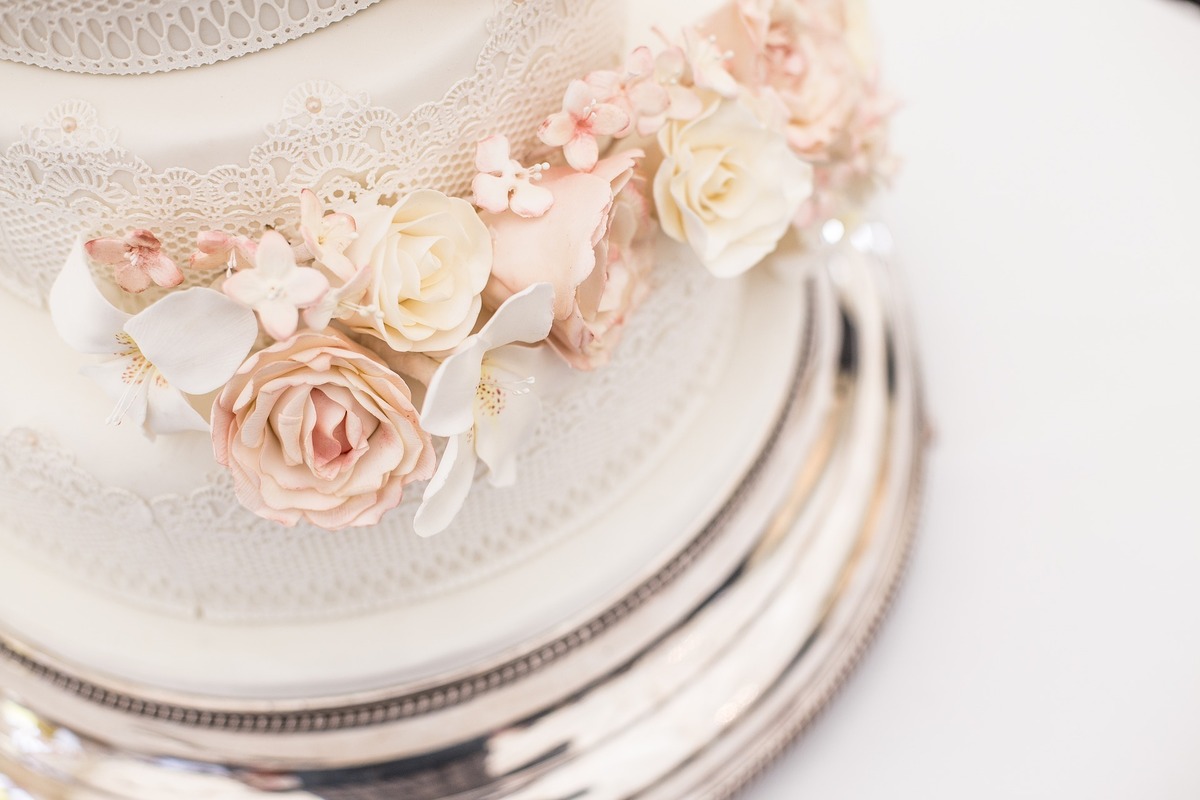 Bolo de casamento branco com flores decorativas. 