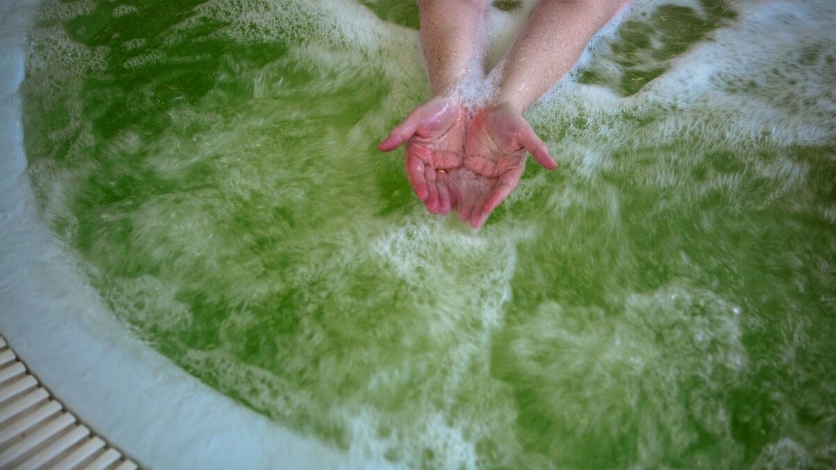 Mãos em uma banheira com espuma.