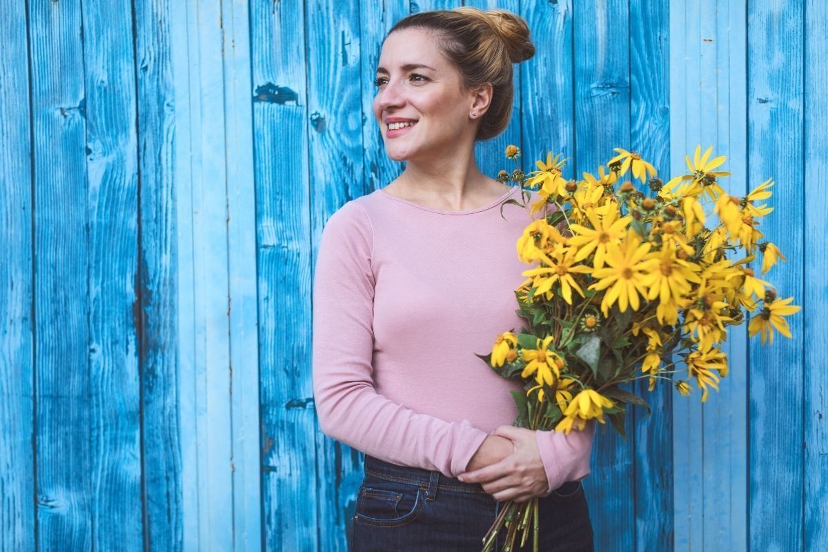 Mulher segurando um buquê de flores amarelas