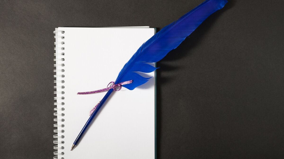 Caneta de pena com um caderno.