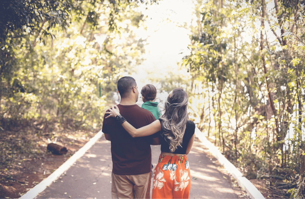 Família em uma estrada rodeada de floresta