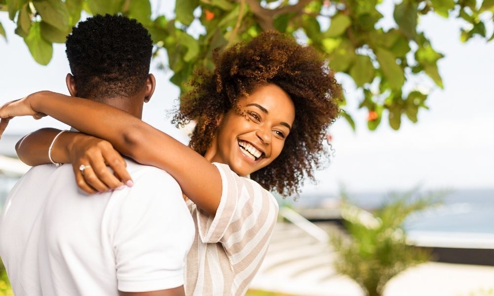 Casal abraçado e sorridente.