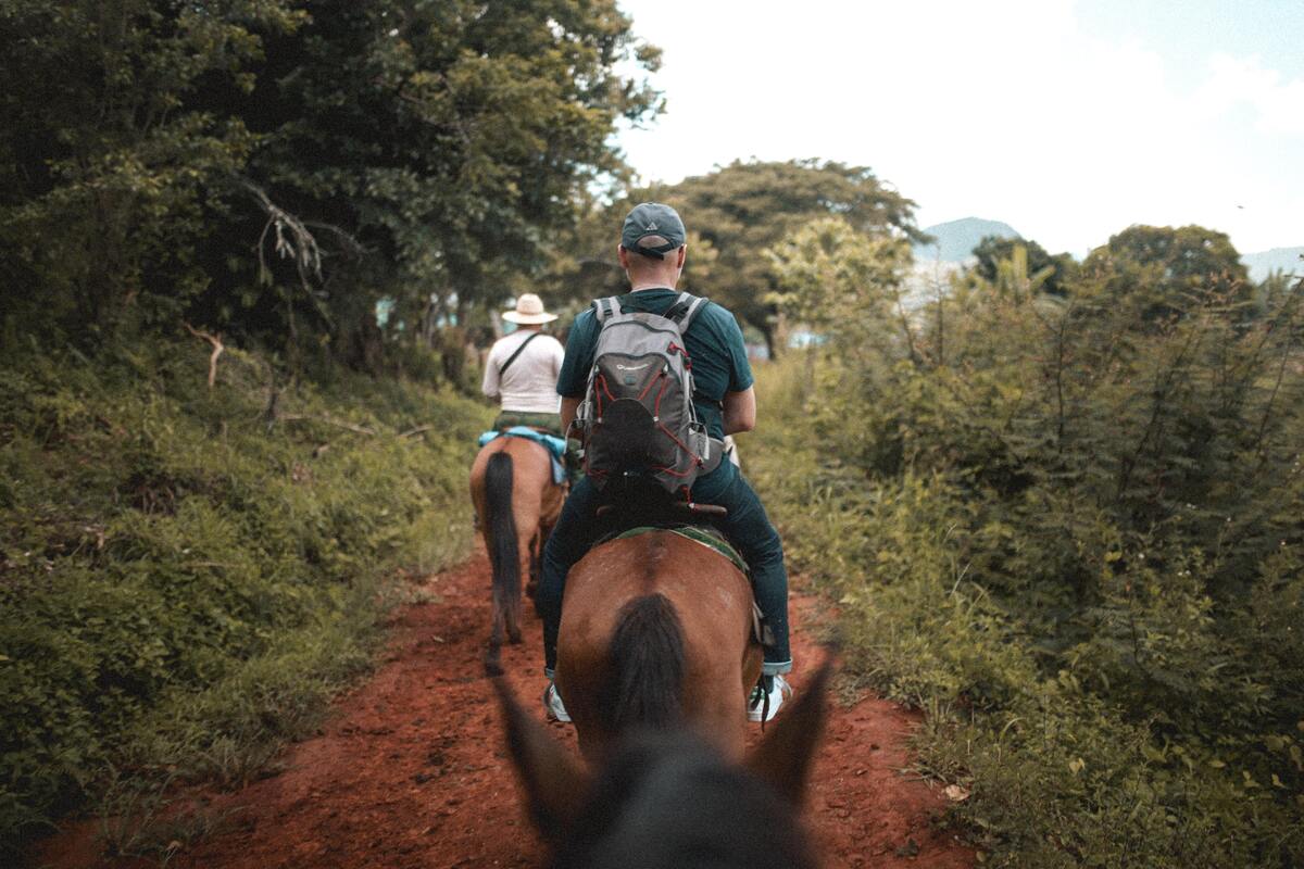 Pessoas andando a cavalo.