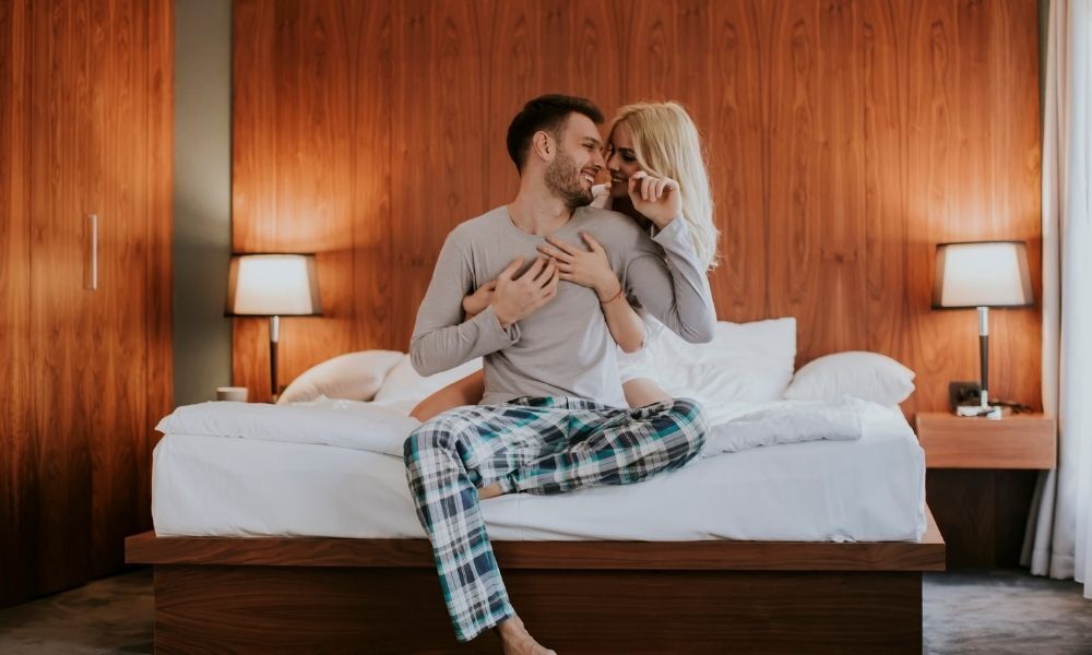 Casal abraçado na cama.