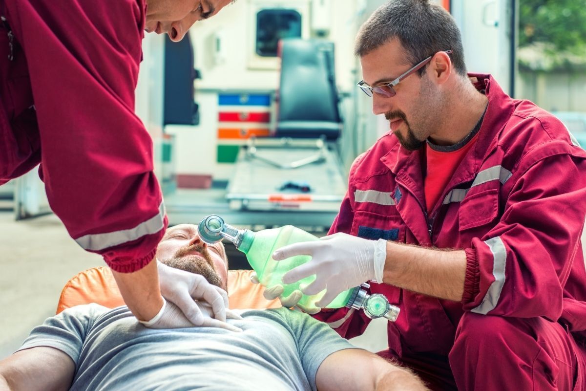 Homem em uma maca sendo socorrido por médicos