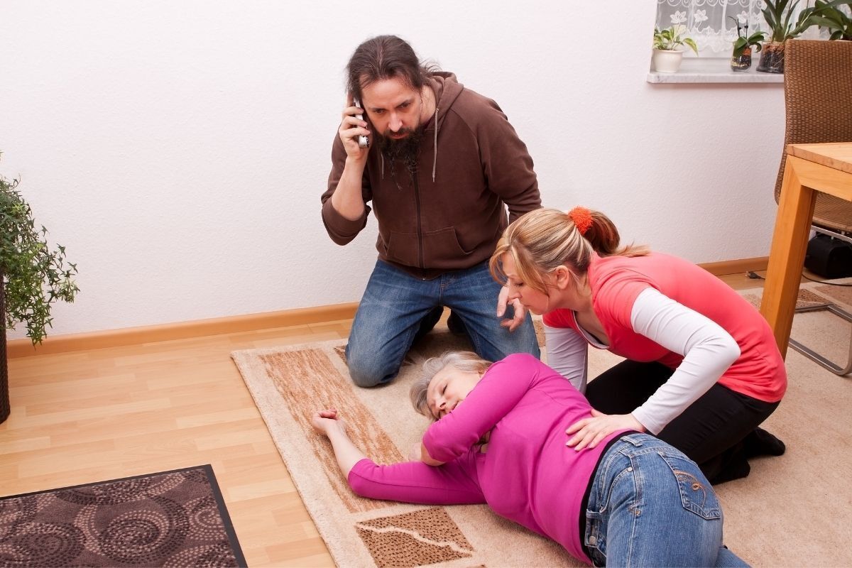 Mulher passando mal sendo socorrida por familiares