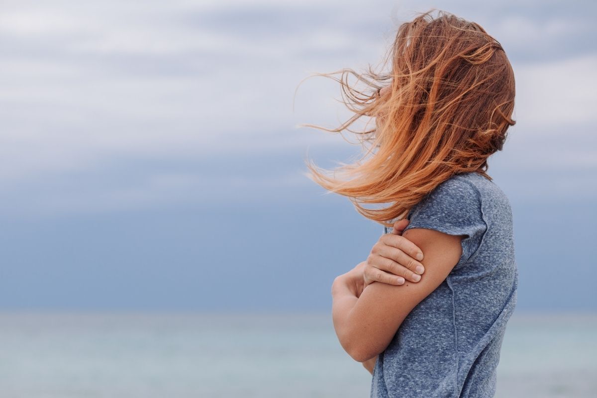 Mulher sozinha e triste perto do mar