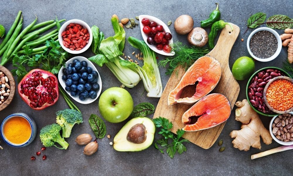 Alimentos e verduras espalhados sobre a mesa.