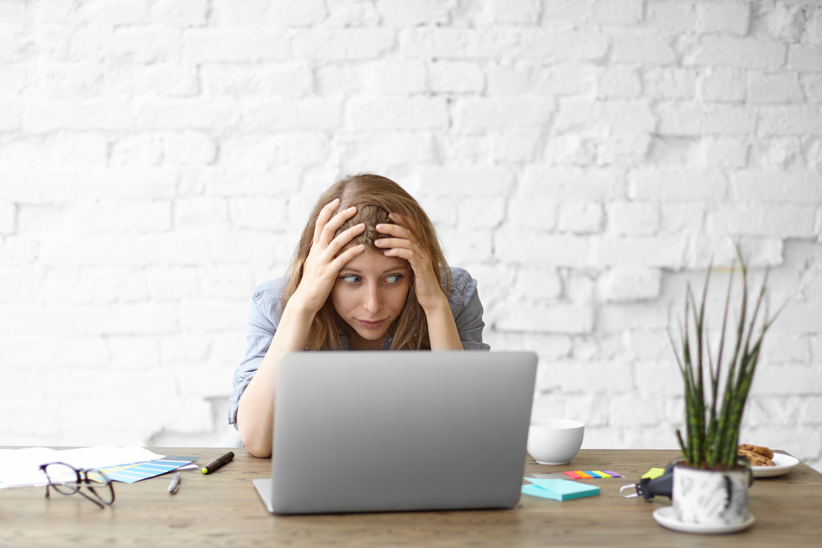 Mulher preocupada em frente a notebook