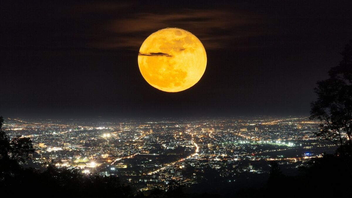 Lua cheia em cima de uma cidade.