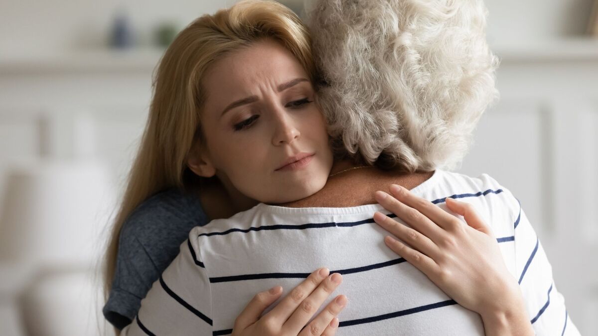 Mulher abraçando uma senhora.