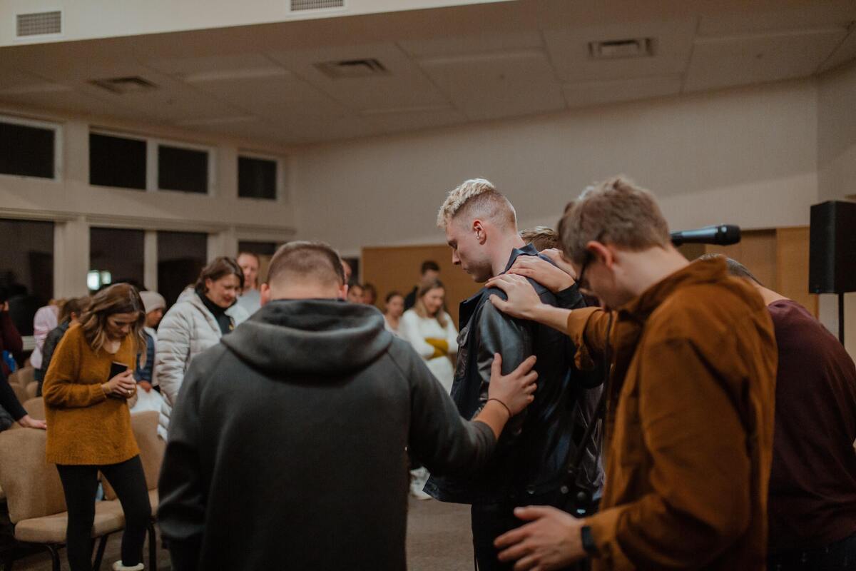 Pessoas rezando dentro de uma Igreja.