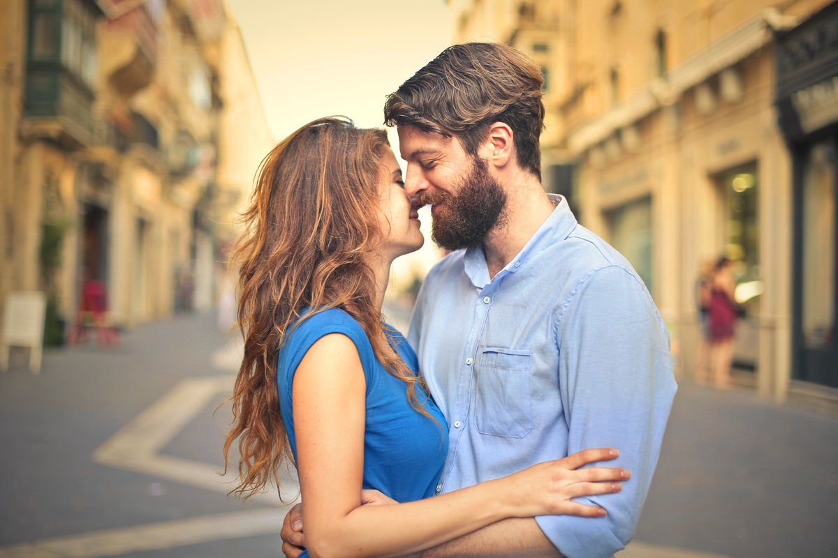 Homem beijando ex-esposa ao ar livre.