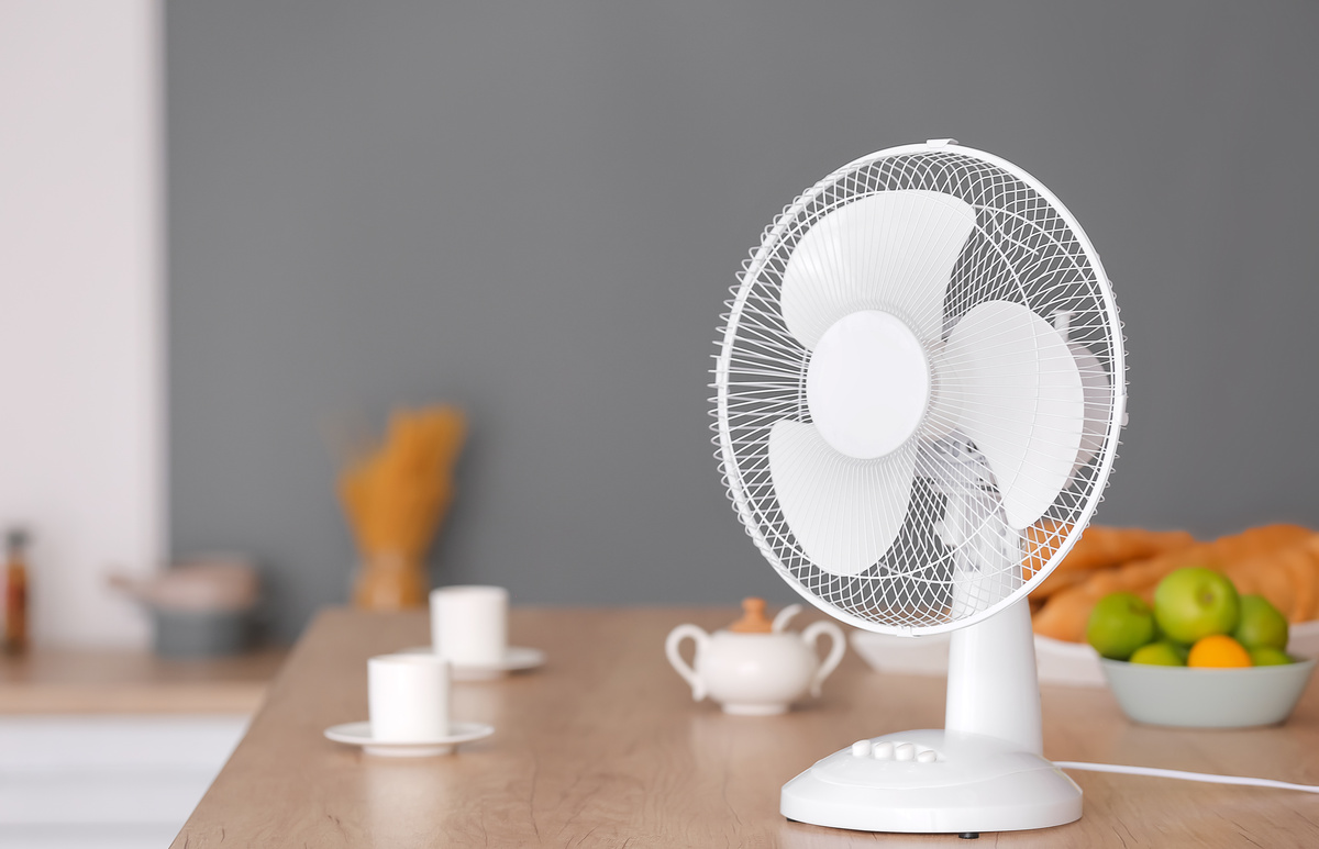 Ventilador branco em cima de mesa