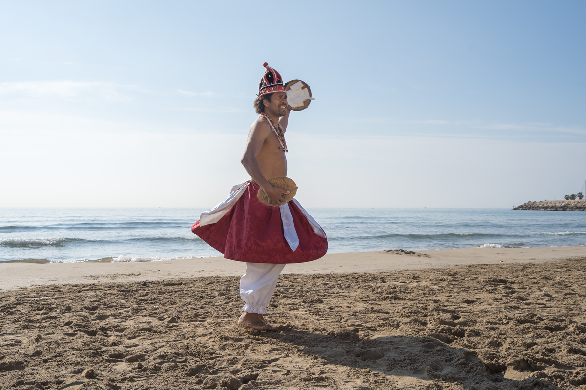 Homem na praia vestido de Xangô