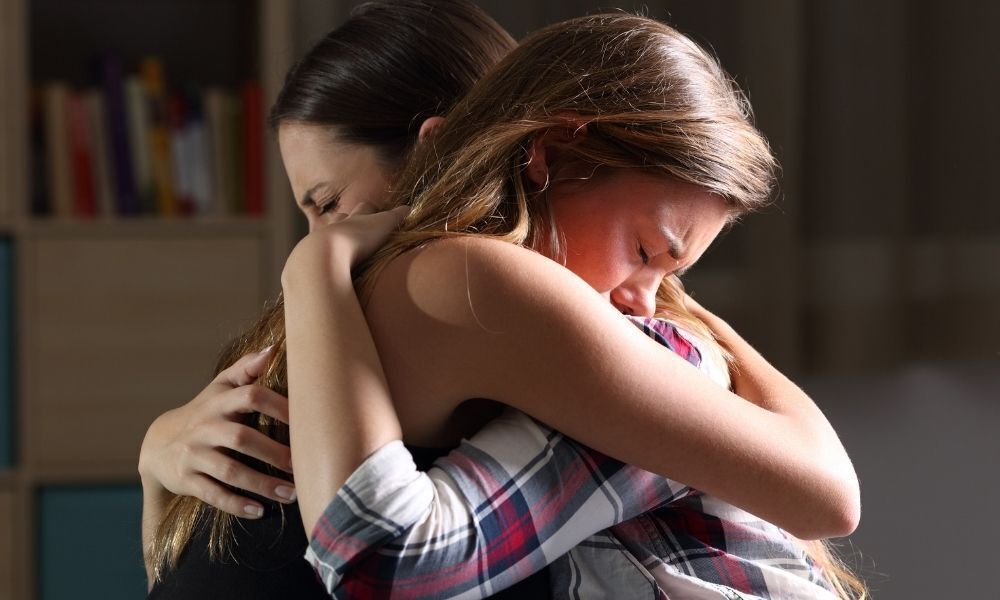 Mãe abraçando e se reconciliando com a filha.