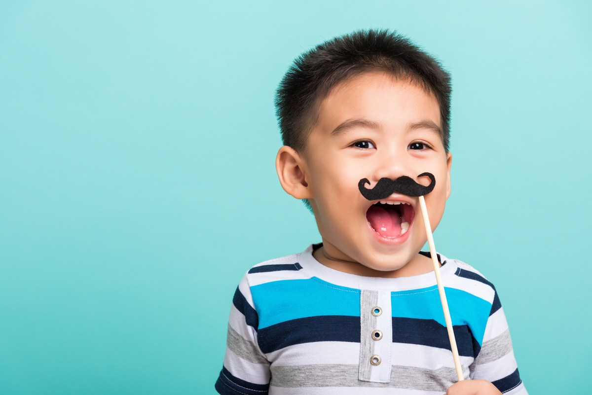 Criança com bigode de papel