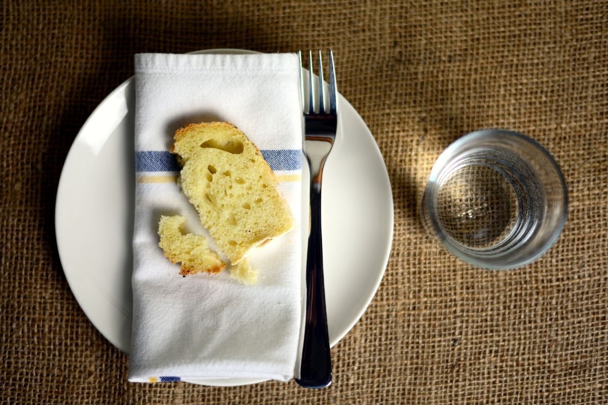 Prato com pão e copo com água.