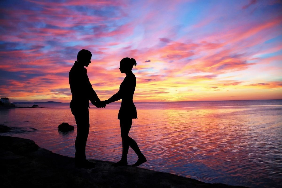 Casal de mãos dadas na praia