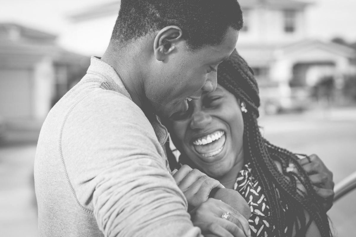 Casal abraçado e sorrindo.