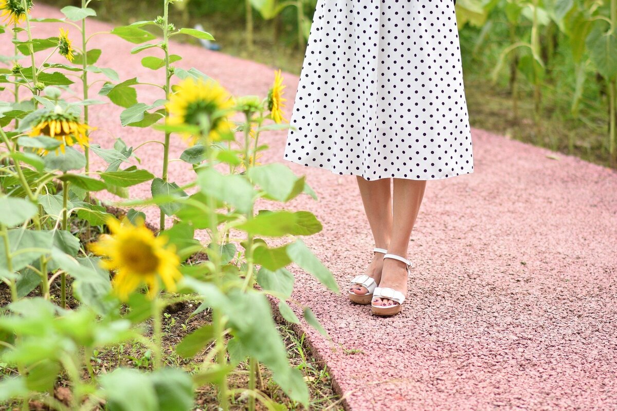 Mulher de vestido no jardim.