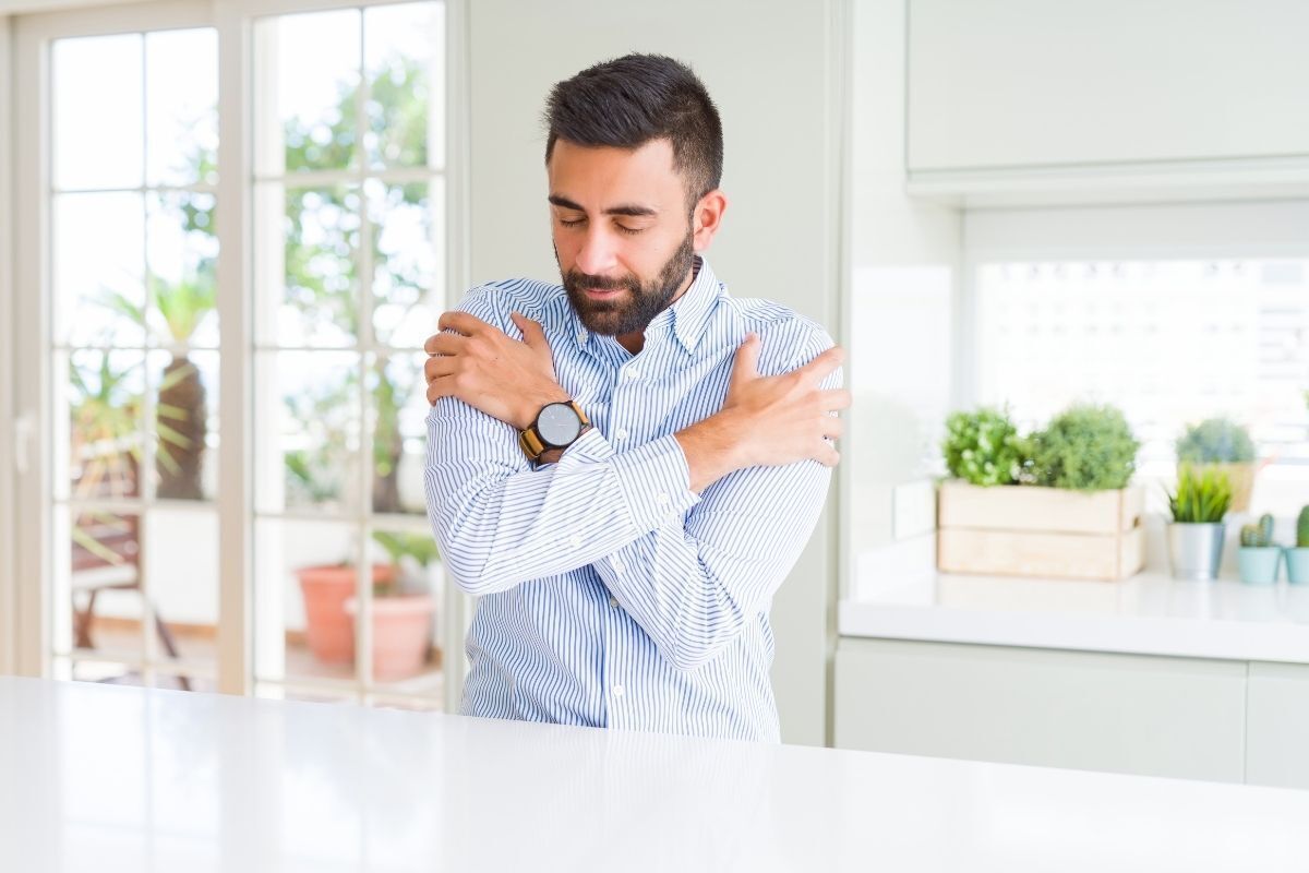 Homem feliz e abraçando a si mesmo.