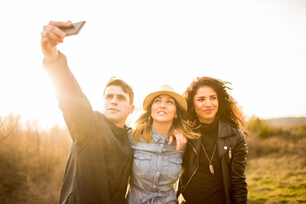 Três amigos pousando para uma selfie