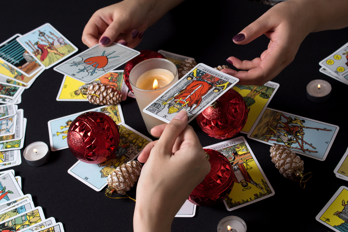 Duas pessoas tirando cartas do baralho cigano.