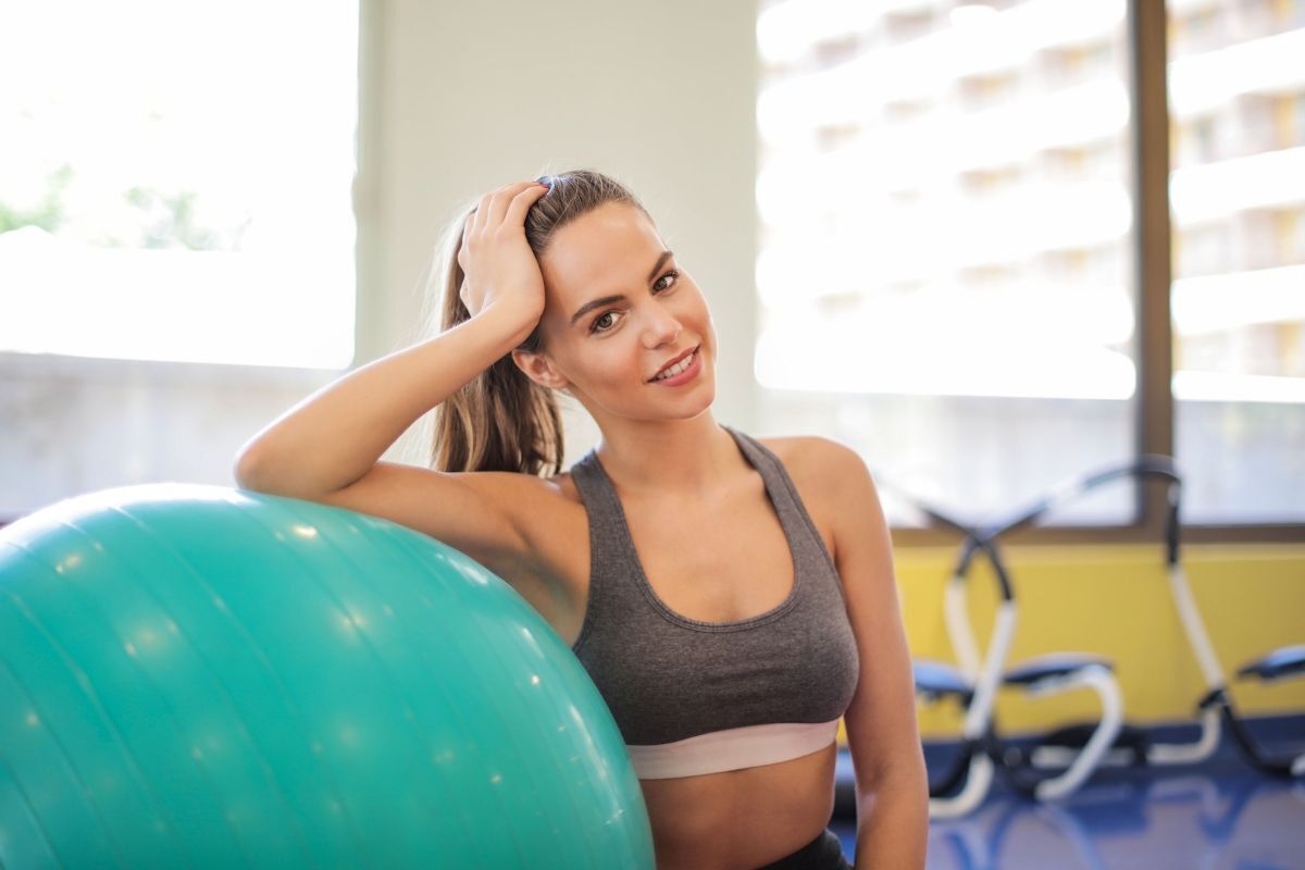 Mulher sorrindo para a foto em uma academia