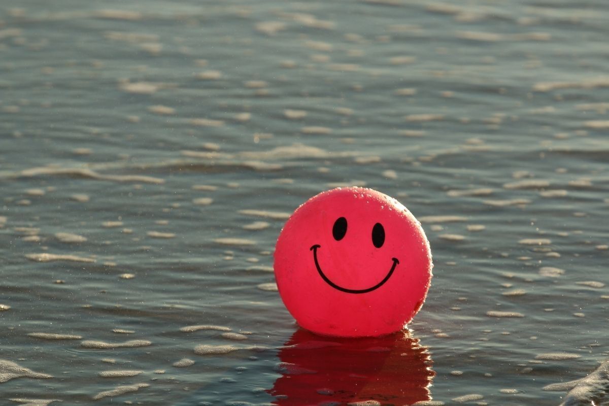 Rosto feliz em bolinha no mar.