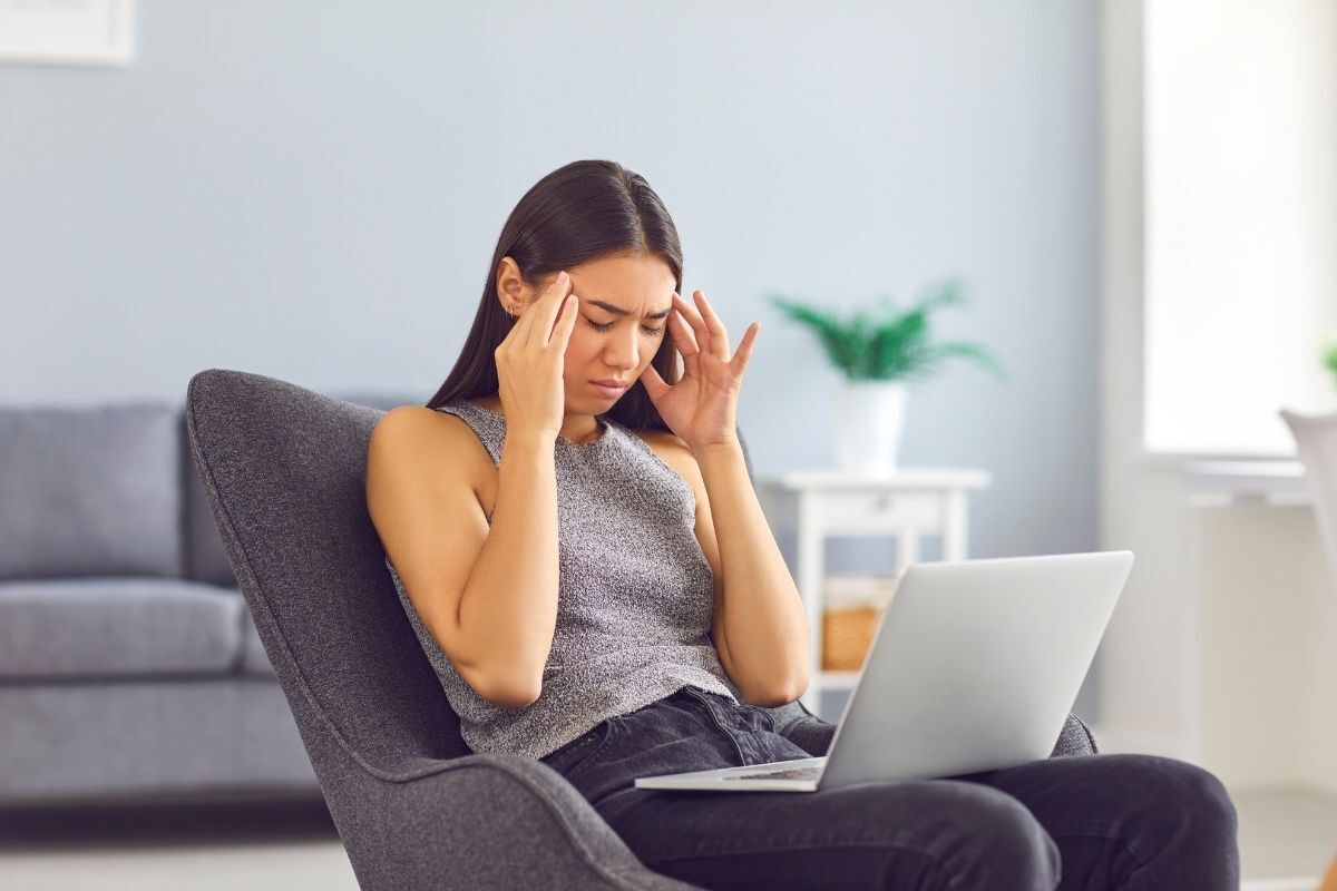 Mulher ansiosa com um laptop em seu colo