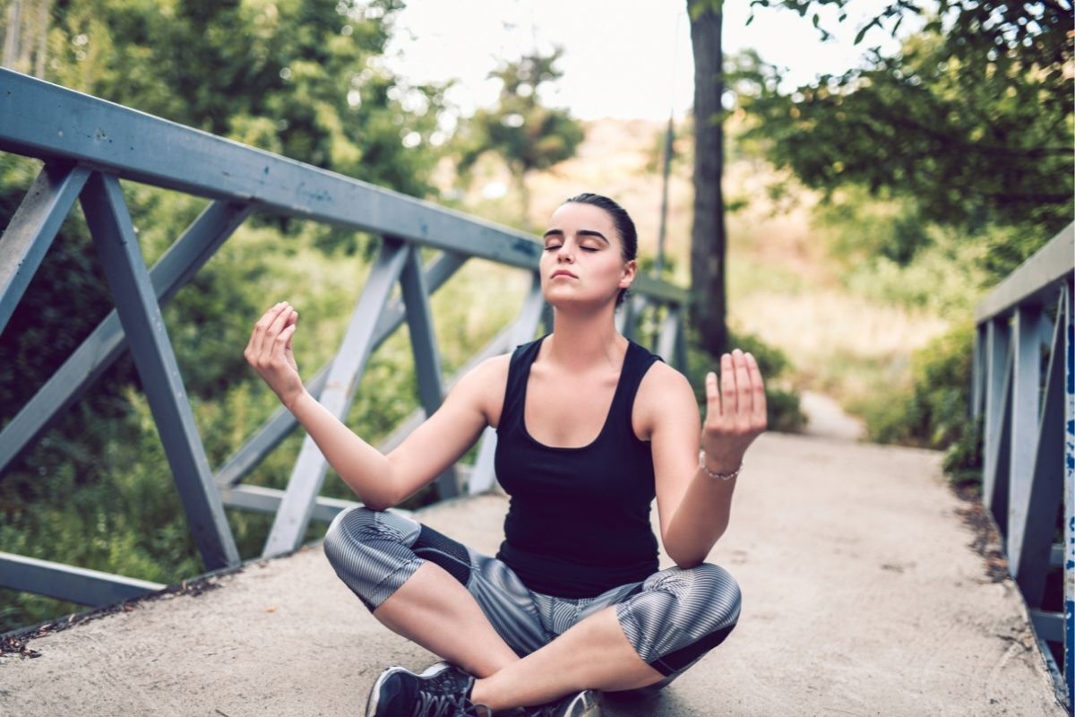 Mulher meditando em uma ponte