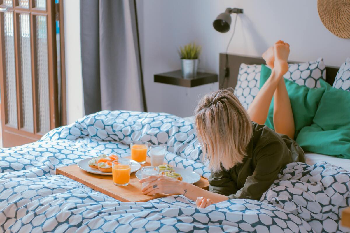 Mulher tomando café da manhã na cama.