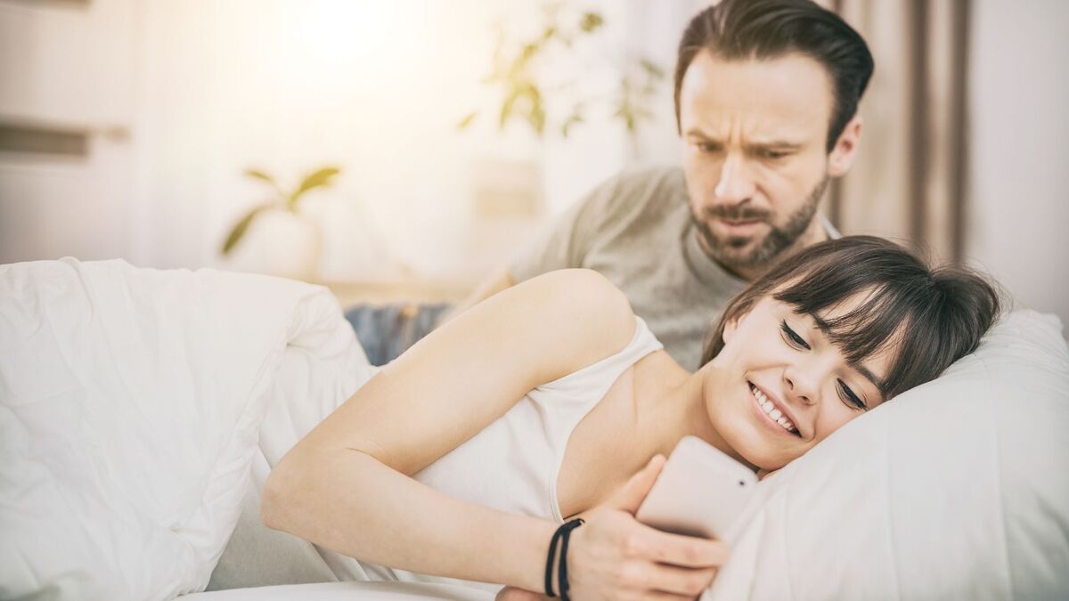 Homem com ciúmes da mulher na cama.