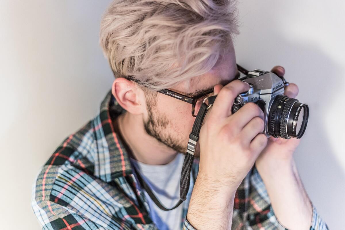 Homem loiro tirando foto.