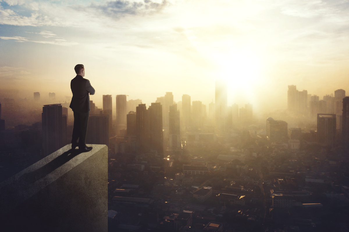 Homem observando cidade de cima de um prédio